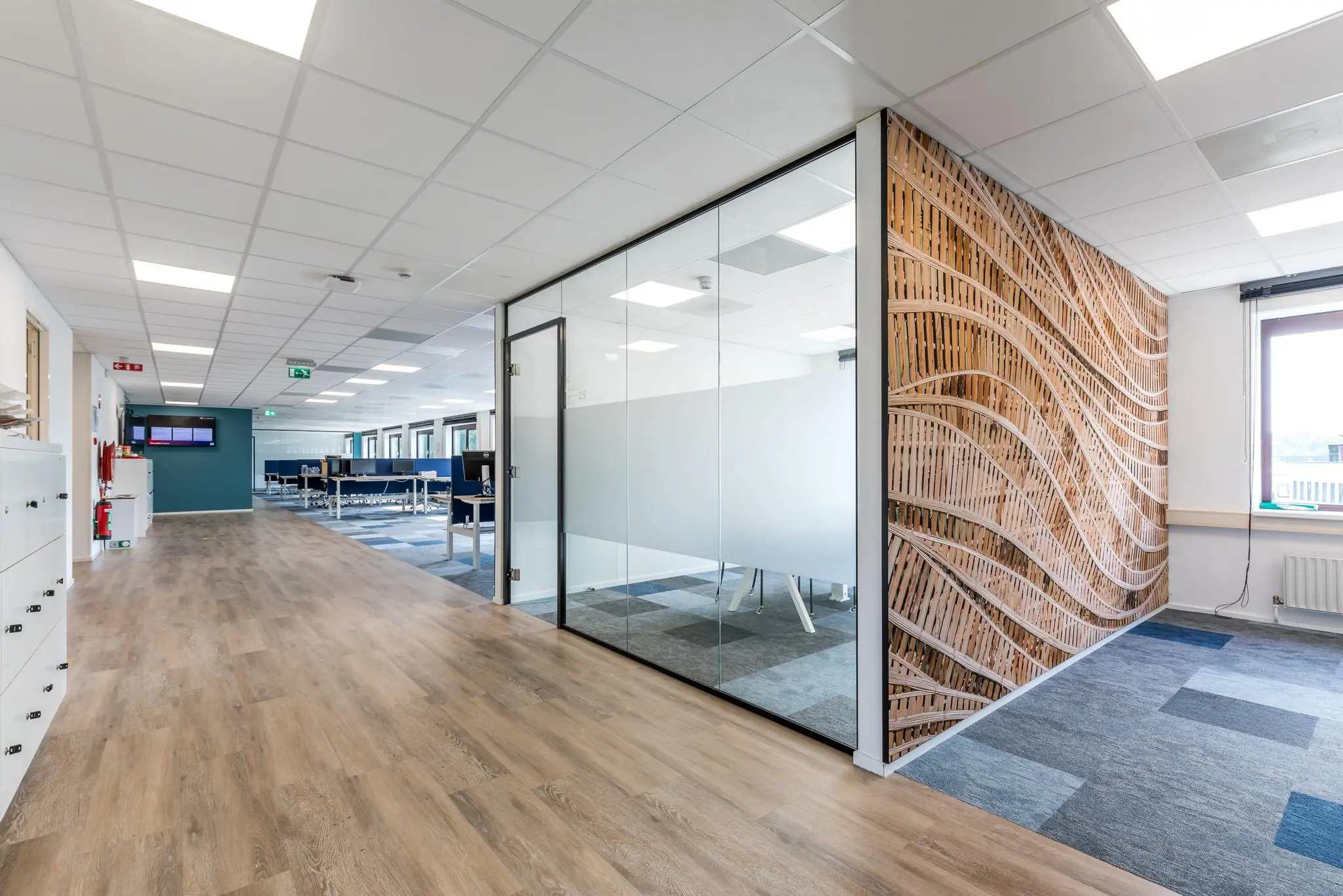 Moderne kantoorruimte aan de Baarnsche Dijk met glazen vergaderruimte en een opvallende houten designwand.